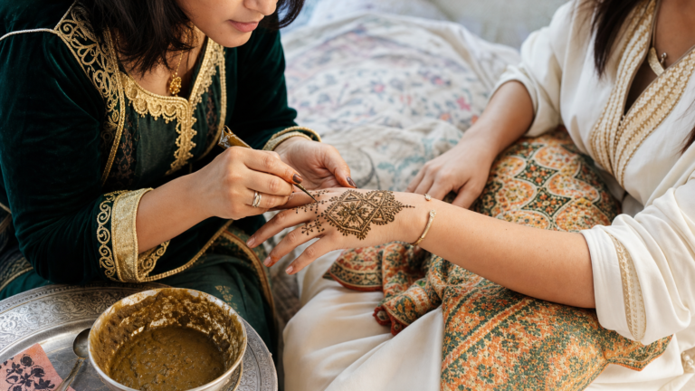 Moroccan henna artist applying a geometric pattern during a family celebration