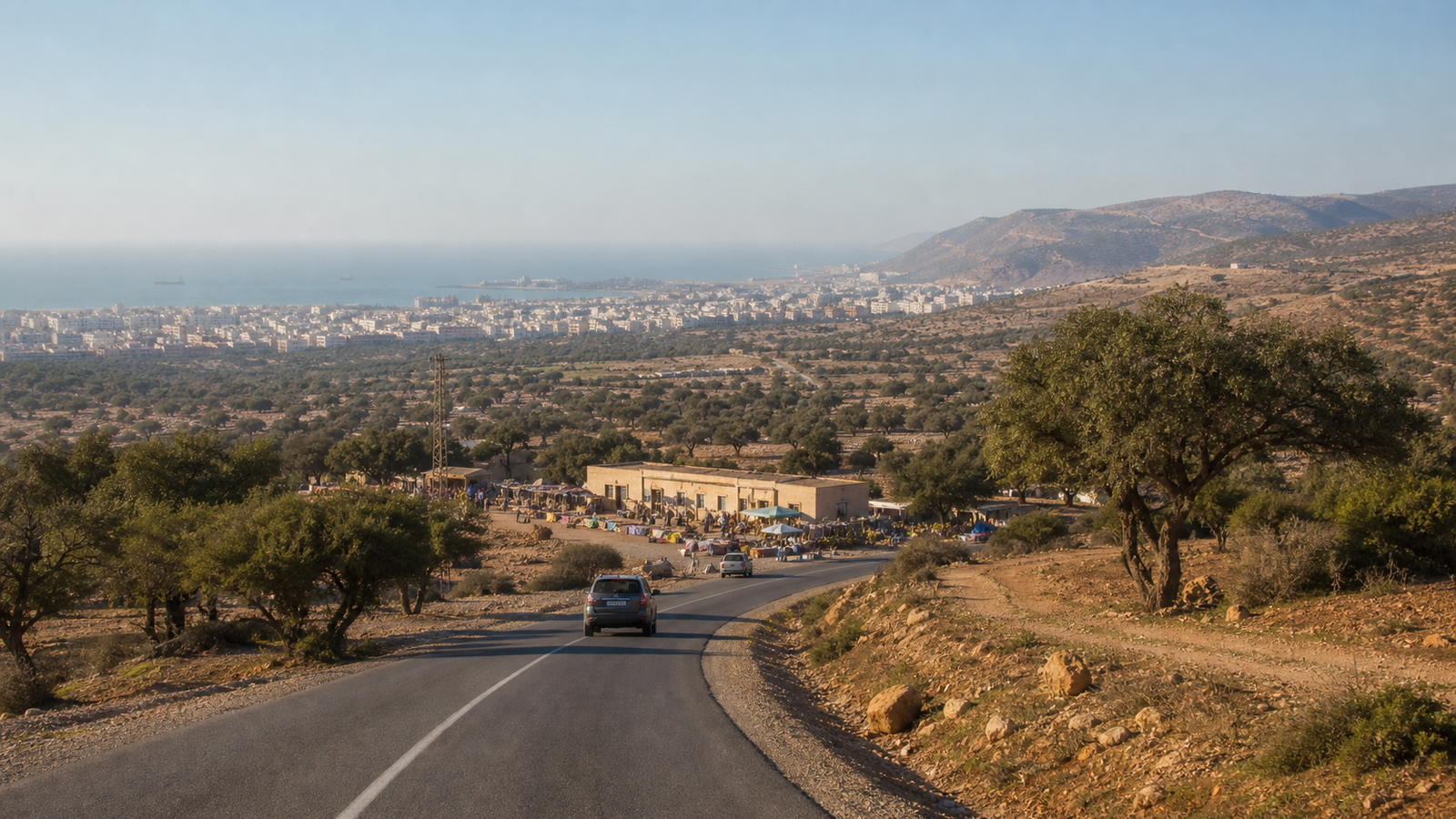 Road through argan country in the Souss with Agadir and the Atlantic behind